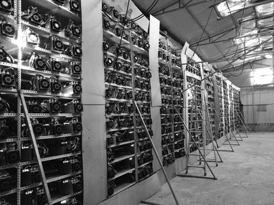 A large-scale mining farm illuminated by the glow of dozens of mining rigs